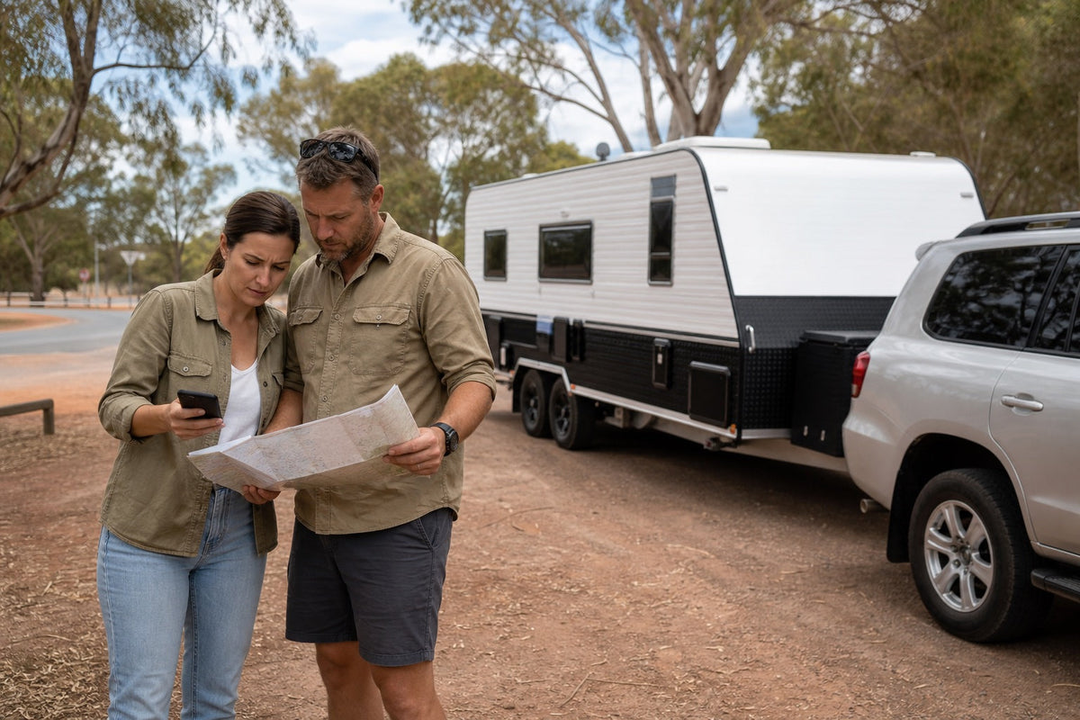 Australian couple planning an interstate caravan collection route beside a caravan and tow vehicle